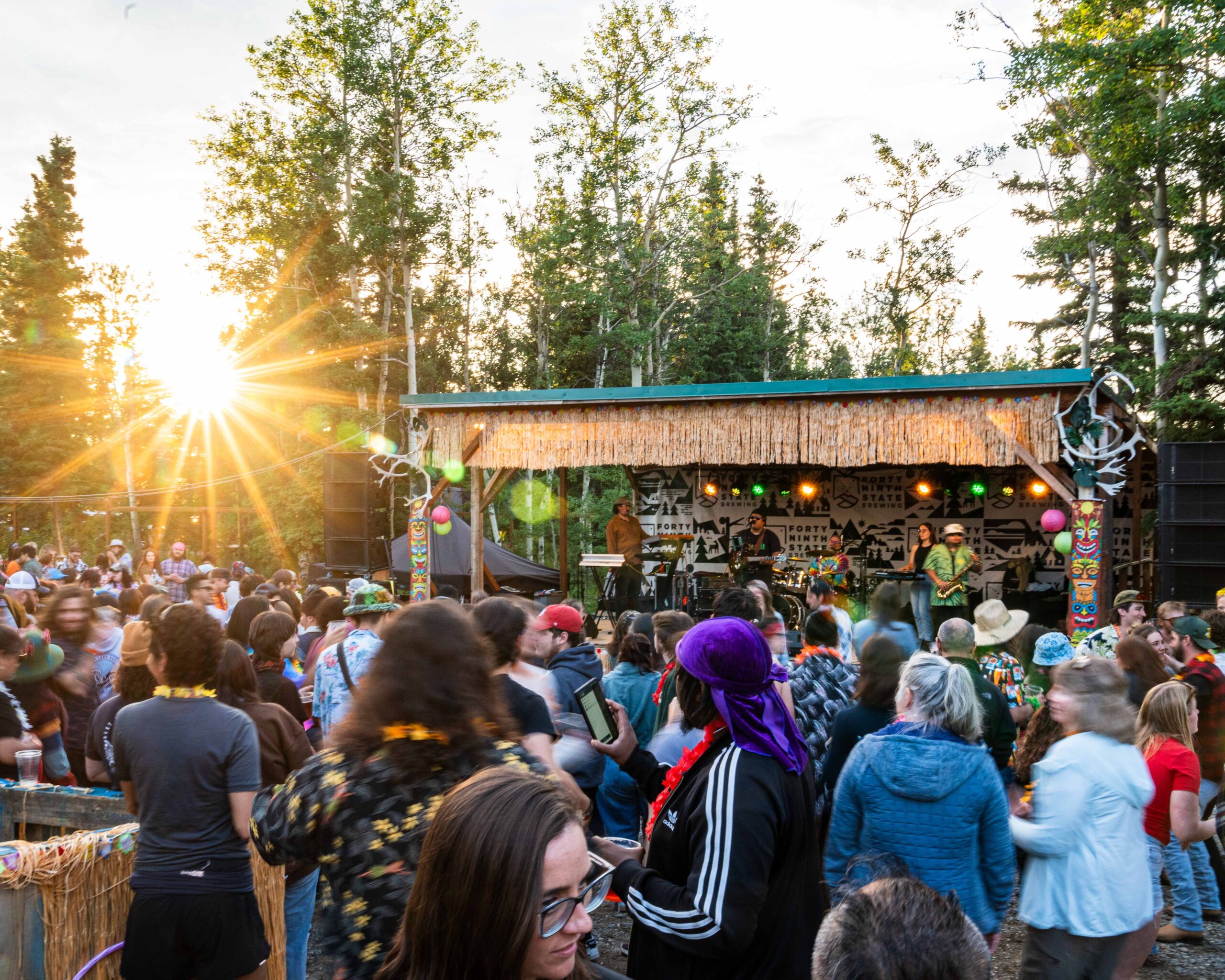 People dancing in the sun enjoying the music onstage